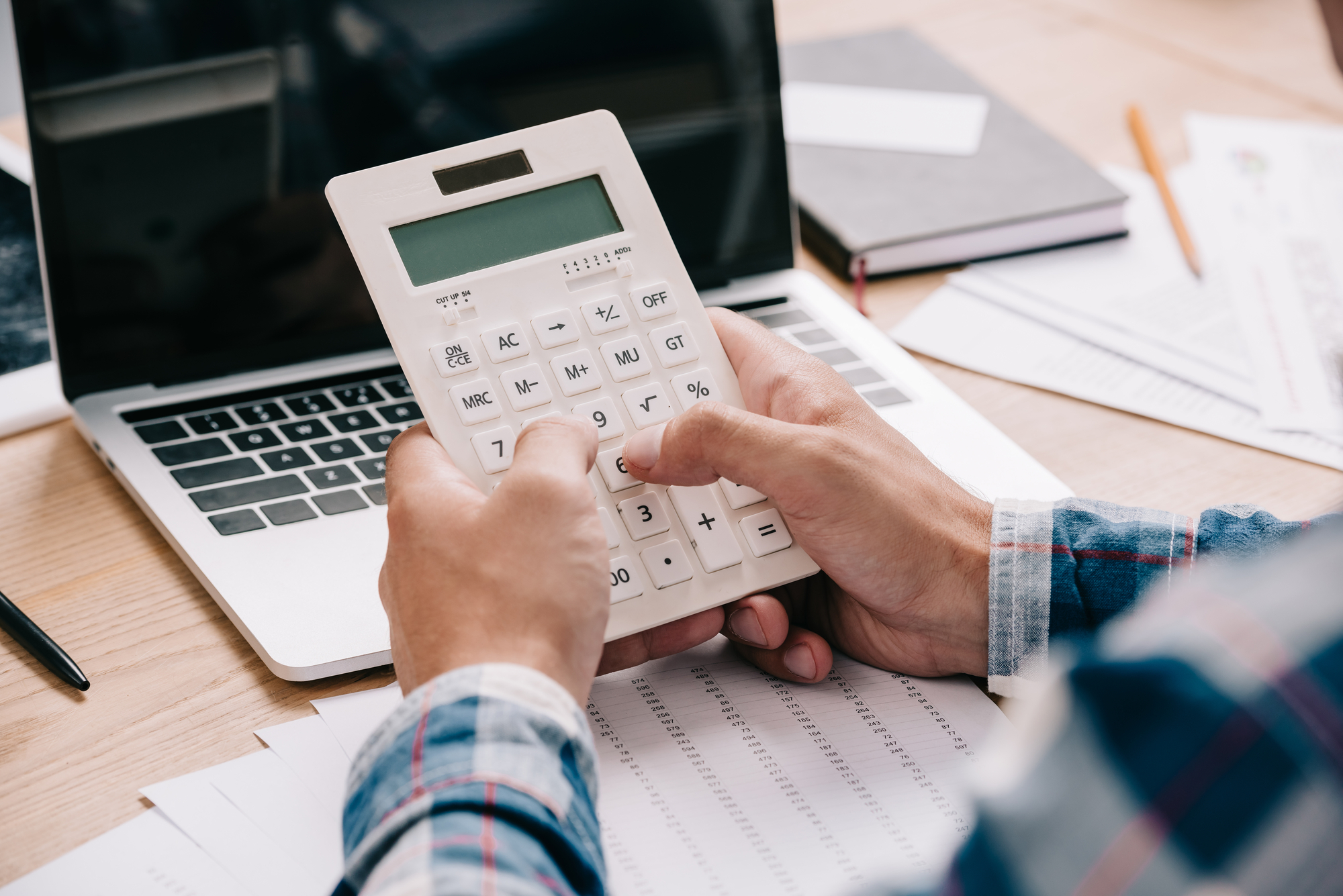 man holding white calculator